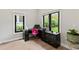 Well-lit home office with black desk, bright pink chair, and large windows showcasing the lush outdoor scenery at 1521 Sylvan Sw Rd, Atlanta, GA 30310