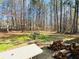 Relaxing backyard scene with swing bench, stack of firewood and view of tall trees at 33 Bo Xing, Temple, GA 30179