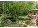 Backyard oasis featuring a pond, lush landscaping, and screened porch at 5240 Arrie Way, Atlanta, GA 30360