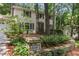 View of a two-story home with trees surrounding it and a stone wall in the front at 5240 Arrie Way, Atlanta, GA 30360
