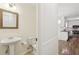 Powder room featuring pedestal sink and decorative mirror adjacent to kitchen at 5240 Arrie Way, Atlanta, GA 30360