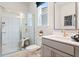 A bright, clean bathroom includes a double vanity, enclosed glass shower, and toilet at 102 Sheryl Way, Loganville, GA 30052