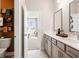 Dual-sink bathroom featuring modern fixtures, stylish cabinets, and an open doorway to a bedroom at 102 Sheryl Way, Loganville, GA 30052