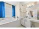 Bathroom featuring a soaking tub, window with blinds, and white vanity at 3485 Palisade Lake Dr, Duluth, GA 30096