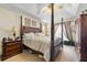 Spacious primary bedroom with a four-poster bed, carpeting, and warm, inviting lighting at 3485 Palisade Lake Dr, Duluth, GA 30096