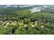 An aerial view shows the property close to a body of water and surrounded by mature trees in a neighborhood at 5510 Pilgrim Point Ext, Cumming, GA 30041