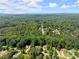 Aerial view shows homes surrounded by many mature trees and other greenery at 5510 Pilgrim Point Ext, Cumming, GA 30041