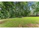 A lush backyard with mature trees and a trampoline at 5510 Pilgrim Point Ext, Cumming, GA 30041