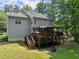 View of the home's backyard showcasing a spacious deck, outdoor entertaining area, and lush greenery at 5510 Pilgrim Point Ext, Cumming, GA 30041