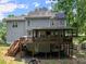 View of the home's backyard showcasing a spacious deck, outdoor entertaining area, and lush greenery at 5510 Pilgrim Point Ext, Cumming, GA 30041