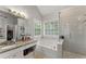 Bright bathroom with a large soaking tub, tiled shower and granite countertops at 5510 Pilgrim Point Ext, Cumming, GA 30041