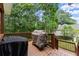 Wooden deck with outdoor cooking equipment and railing at 5510 Pilgrim Point Ext, Cumming, GA 30041