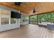 Covered wooden deck featuring an outdoor TV and ceiling fans at 5510 Pilgrim Point Ext, Cumming, GA 30041