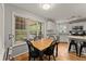 Bright dining area with hardwood floors, white cabinets, granite countertops, and view of the deck at 5510 Pilgrim Point Ext, Cumming, GA 30041