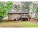 A backyard view featuring a small wooden deck and a low-maintenance lawn, surrounded by mature trees at 2139 Jonathan Ave, Lithonia, GA 30058