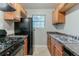 A well-lit kitchen featuring dark appliances, granite countertops, and wood cabinets at 2139 Jonathan Ave, Lithonia, GA 30058