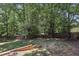 Large backyard featuring mature trees and a wood fence at 3850 Stepney Way, Cumming, GA 30041
