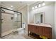 Bathroom featuring a tiled shower with a glass door and a wooden vanity with granite countertop at 3850 Stepney Way, Cumming, GA 30041