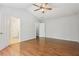Bedroom with hardwood floors and a ceiling fan, leading to the hallway and bathroom at 3850 Stepney Way, Cumming, GA 30041