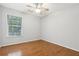 Bright bedroom with hardwood floors, ceiling fan, and a window offering natural light at 3850 Stepney Way, Cumming, GA 30041