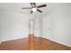 Bedroom with hardwood floors and a ceiling fan, leading to the bathroom at 3850 Stepney Way, Cumming, GA 30041