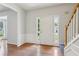 Bright foyer featuring hardwood floors and staircase with wooden handrail at 3850 Stepney Way, Cumming, GA 30041