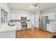 Kitchen featuring stainless steel appliances, white cabinets, and hardwood floors at 3850 Stepney Way, Cumming, GA 30041