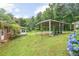 Large, grassy backyard with a covered area for storage, bordered by trees, showing a serene outdoor space at 695 Hiram Sudie Rd, Dallas, GA 30157
