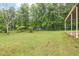 Expansive green backyard with mature trees providing shade and privacy, showcasing a tranquil outdoor setting at 695 Hiram Sudie Rd, Dallas, GA 30157