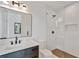 Bathroom featuring dark vanity with marble countertop, glass shower with white tile, and bronze hardware at 115 Nova Lane, Roswell, GA 30075