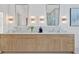 Modern bathroom features a double vanity, marble countertops, decorative lighting, and stylish framed mirrors at 115 Nova Lane, Roswell, GA 30075