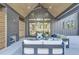 Covered patio with comfortable seating, fireplace, and views of the landscaped yard at 115 Nova Lane, Roswell, GA 30075