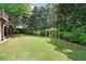 Lush, green backyard with well-manicured lawn and mature trees, perfect for outdoor activities at 1415 Liberty Ln, Cumming, GA 30040
