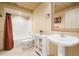 Bathroom featuring stylish wainscoting, a pedestal sink, and tub-shower combo at 1415 Liberty Ln, Cumming, GA 30040