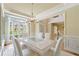 Elegant dining room with large windows, chandelier, and stylish white table and chairs at 1415 Liberty Ln, Cumming, GA 30040