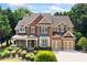 Charming two-story brick home featuring manicured landscaping and a two-car garage at 1415 Liberty Ln, Cumming, GA 30040