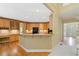Open kitchen features granite countertops, stainless steel appliances, breakfast bar, and wood floors at 1415 Liberty Ln, Cumming, GA 30040