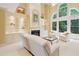 Elegant living room with a fireplace, built-in shelves, and large arched windows overlooking lush greenery at 1415 Liberty Ln, Cumming, GA 30040