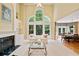 Bright living room with large windows, fireplace and open floor plan to dining area and kitchen at 1415 Liberty Ln, Cumming, GA 30040
