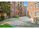 Charming courtyard of a brick condo building, featuring lush landscaping and patio spaces at 1735 Peachtree Ne St # 117, Atlanta, GA 30309