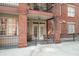 Brick condo patio with chairs, wrought iron fence, and double doors to interior at 1735 Peachtree Ne St # 117, Atlanta, GA 30309