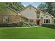 Charming home with a brick and siding exterior, lush lawn, and mature trees at 2011 Sturbridge Ln, Buford, GA 30519