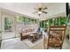 Cozy sunroom with comfortable seating, ceiling fan, and views of the lush, green backyard at 2011 Sturbridge Ln, Buford, GA 30519