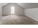 Bright bonus room features vaulted ceilings, neutral walls and carpet, and a window letting in natural light at 2191 Phillips Rd, Lithonia, GA 30058