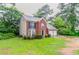 View of the side of a brick home, featuring a two-car garage and well-maintained front lawn at 2191 Phillips Rd, Lithonia, GA 30058