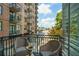 Balcony with wicker chairs overlooking a street with mature trees and a building view at 3235 Roswell Ne Rd # 402, Atlanta, GA 30305