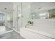 Bright bathroom features a walk-in glass shower, soaking tub, white tile, and large mirrors at 3235 Roswell Ne Rd # 402, Atlanta, GA 30305