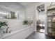 This bright bathroom showcases a soaking tub, white tile, glass brick, and gold shelving at 3235 Roswell Ne Rd # 402, Atlanta, GA 30305