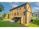 Backyard view of the two-story home featuring a spacious lawn, covered patio and multiple windows at 2482 Brittany Park Ln, Ellenwood, GA 30294