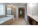 Bathroom includes a large tub, glass shower and double sinks, with tile flooring at 2482 Brittany Park Ln, Ellenwood, GA 30294